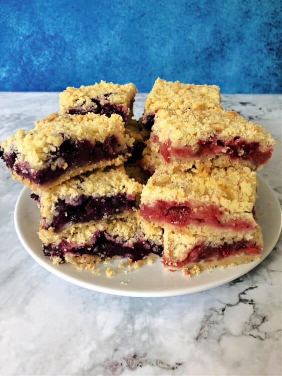 stack of berry crumble bars, blue version on the left and red version on the right