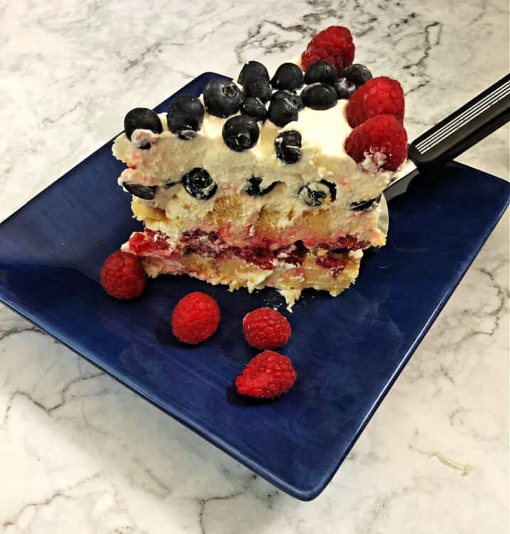 slice od frozen patriotic torte on a blue plate showing the layers