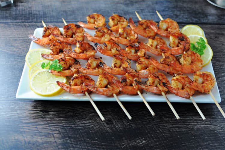 cajun shrimp skewers on a white rectangular platter