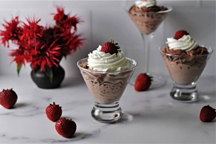 easy chocolate mouse in a glass topped with whipped cream and a strawberry