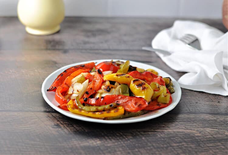 grilled onions and peppers on a small white plate