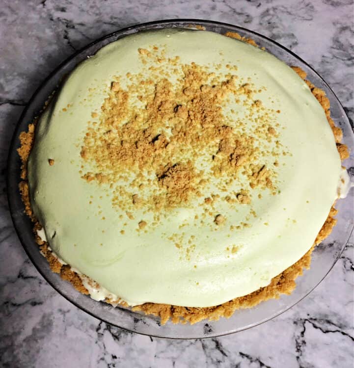 top down view of a whole pie, graham cracker crust with light green filling