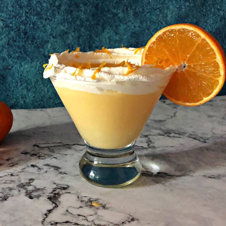 Orange Creamsicle Cocktail in a martini glass garnished with whipped cream