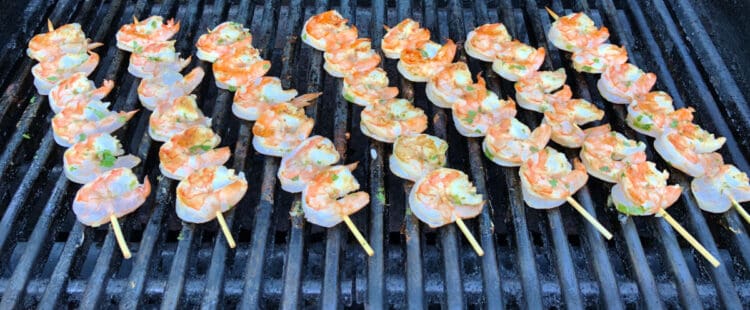 shrimp skewers cooking on grill grates