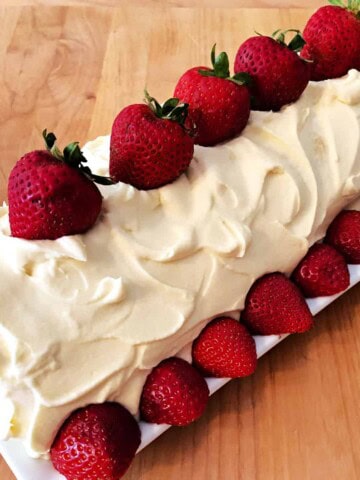 frosted strawberry shortcake roll garnished with fresh strawberries