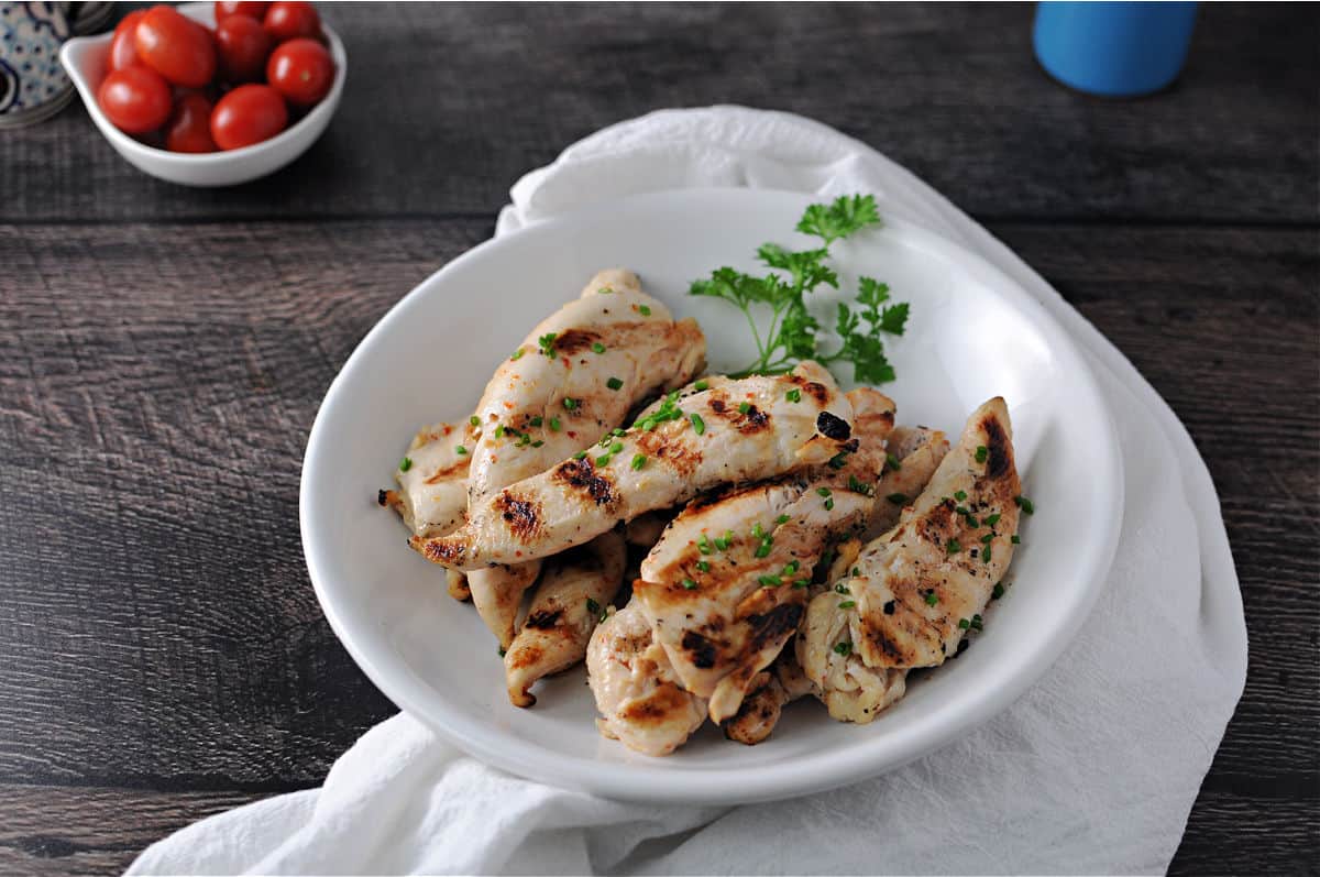 cooked chicken tenderloin strips in a white bowl