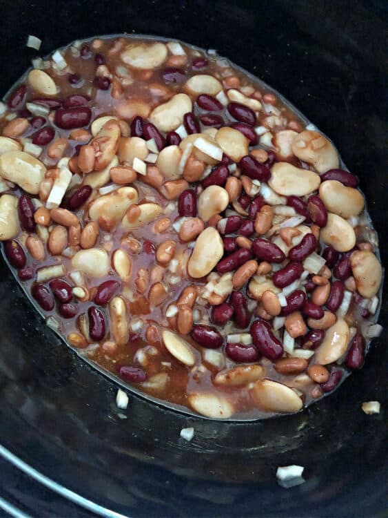 sauce added to slow cooker with beans