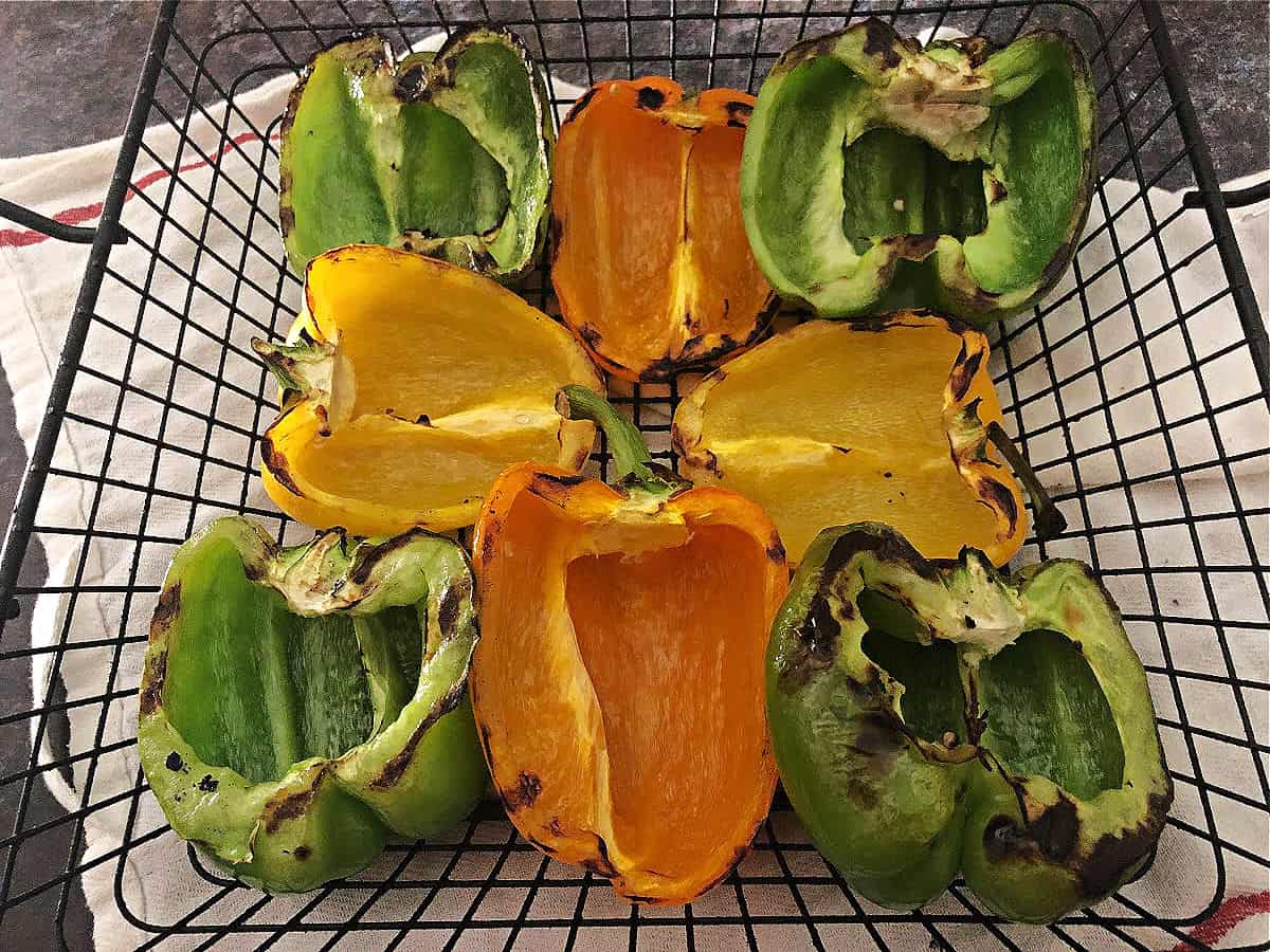 charred pepper halves in a grill basket