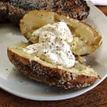 baked potato from the grill served on a white plate