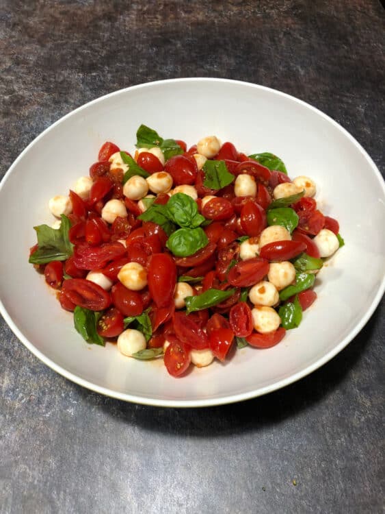 grape tomato mozzarella salad, top down image in a white bowl