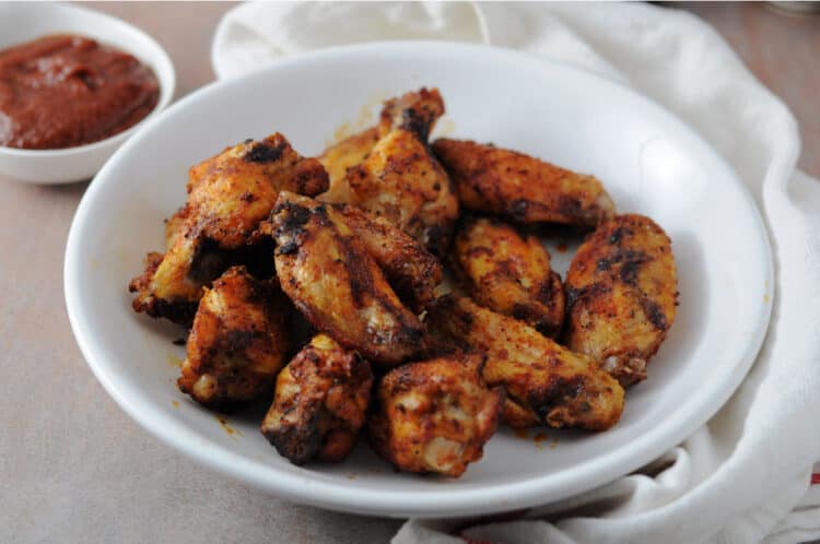 Air fryer BBQ chicken wings in a shallow white bowl for serving