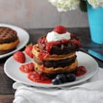 cake mix waffles stacked and topped with berry sauce and whipped cream
