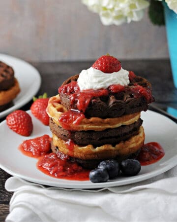 cake mix waffles stacked and topped with berry sauce and whipped cream