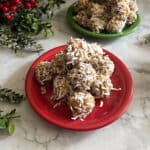 a stack of coconut date balls on a small red plate