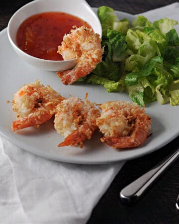 air fryer coconut shrimp on a small plate with dipping sauce