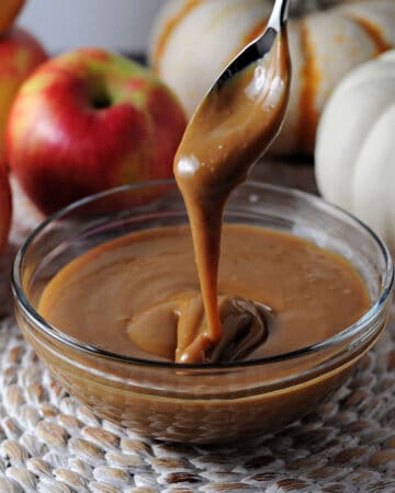 instant pot caramel sauce dripping from a spoon into a bowl