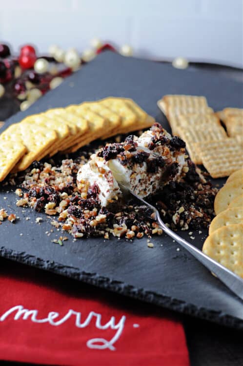 cranberry goat cheese log on a slate cheese board with crackers