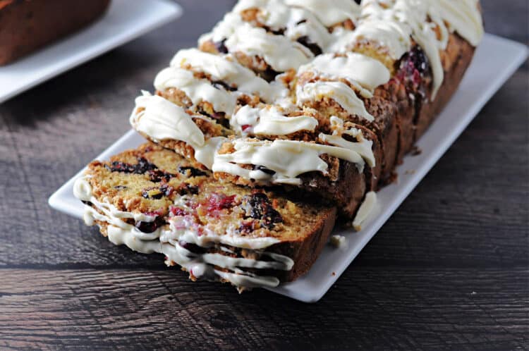 slicedloaf of eggnog cranberry bread on a white platter