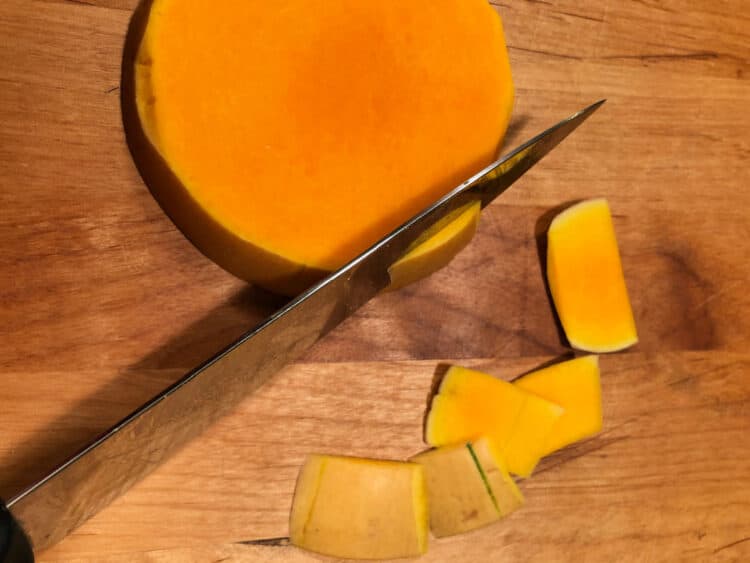 knife cutting skin from each slice of squash
