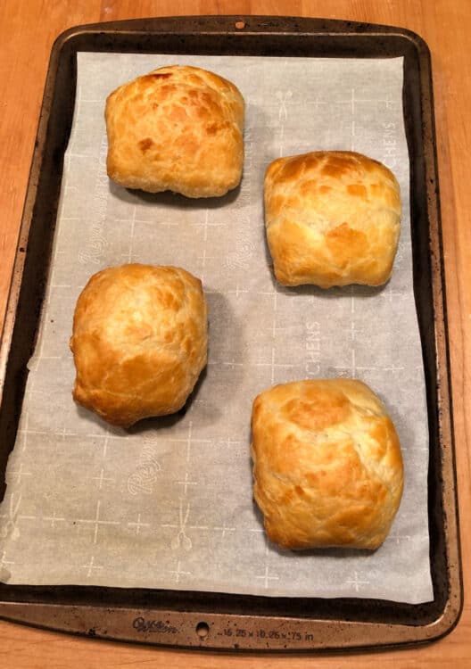 4 baked puff pastry hand pies on the baking sheet
