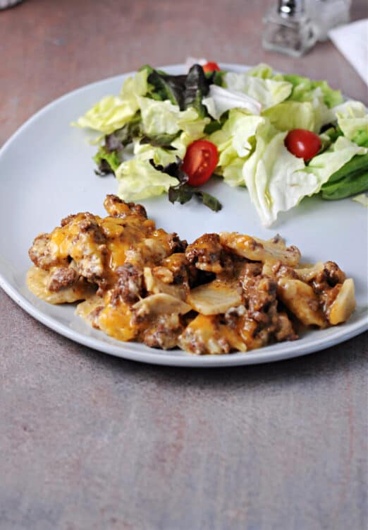 hamburger potato casserole on a plate with green salad