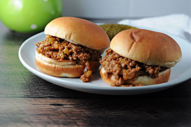 Two sloppy joes on a plate ready to eat.
