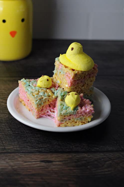 3 peeps rice krispie treats on a plate, decorated with more peeps chicks.