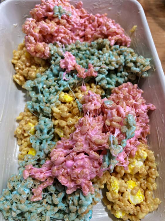 3 colors of peeps rice krispie treat mixture placed in a greased dish.