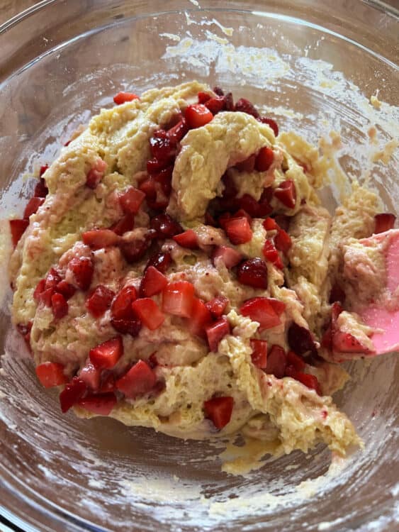 mixing strawberries into the batter.