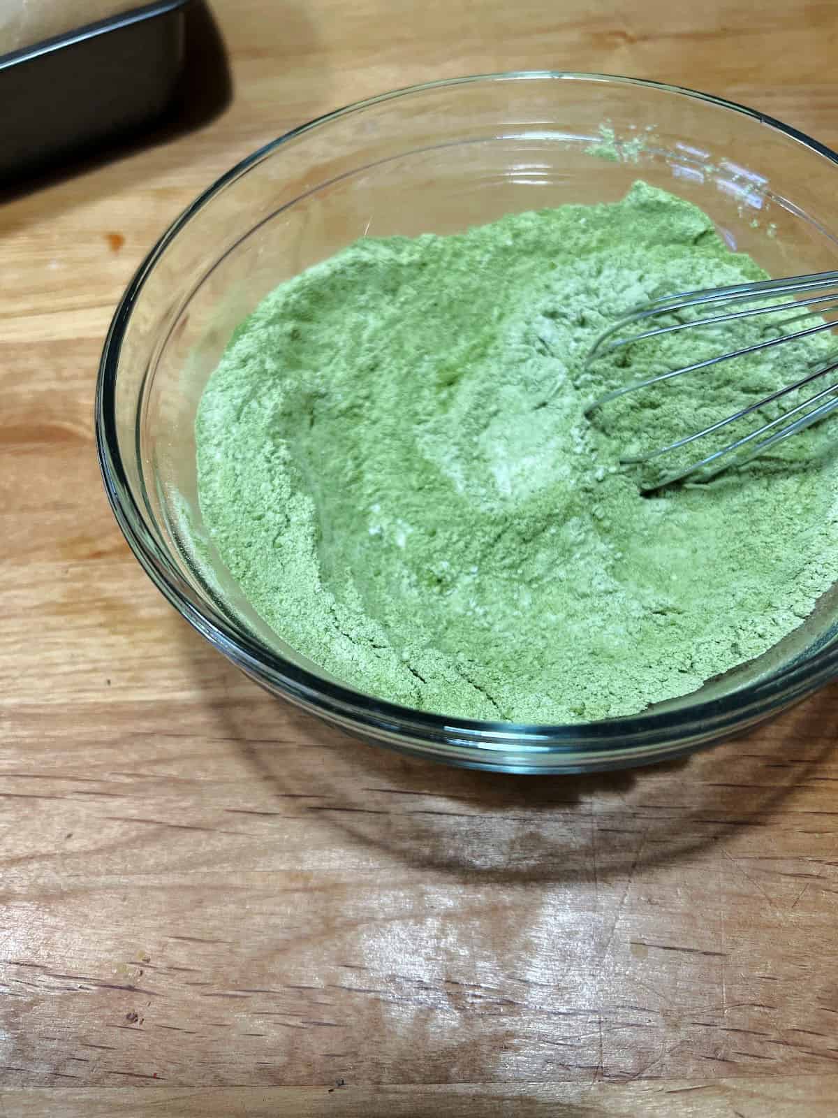dry ingredients with matcha powder mixed in a bowl.