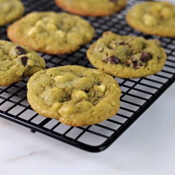 close up of matcha chocolate chip cookies cooling on a wire rack.
