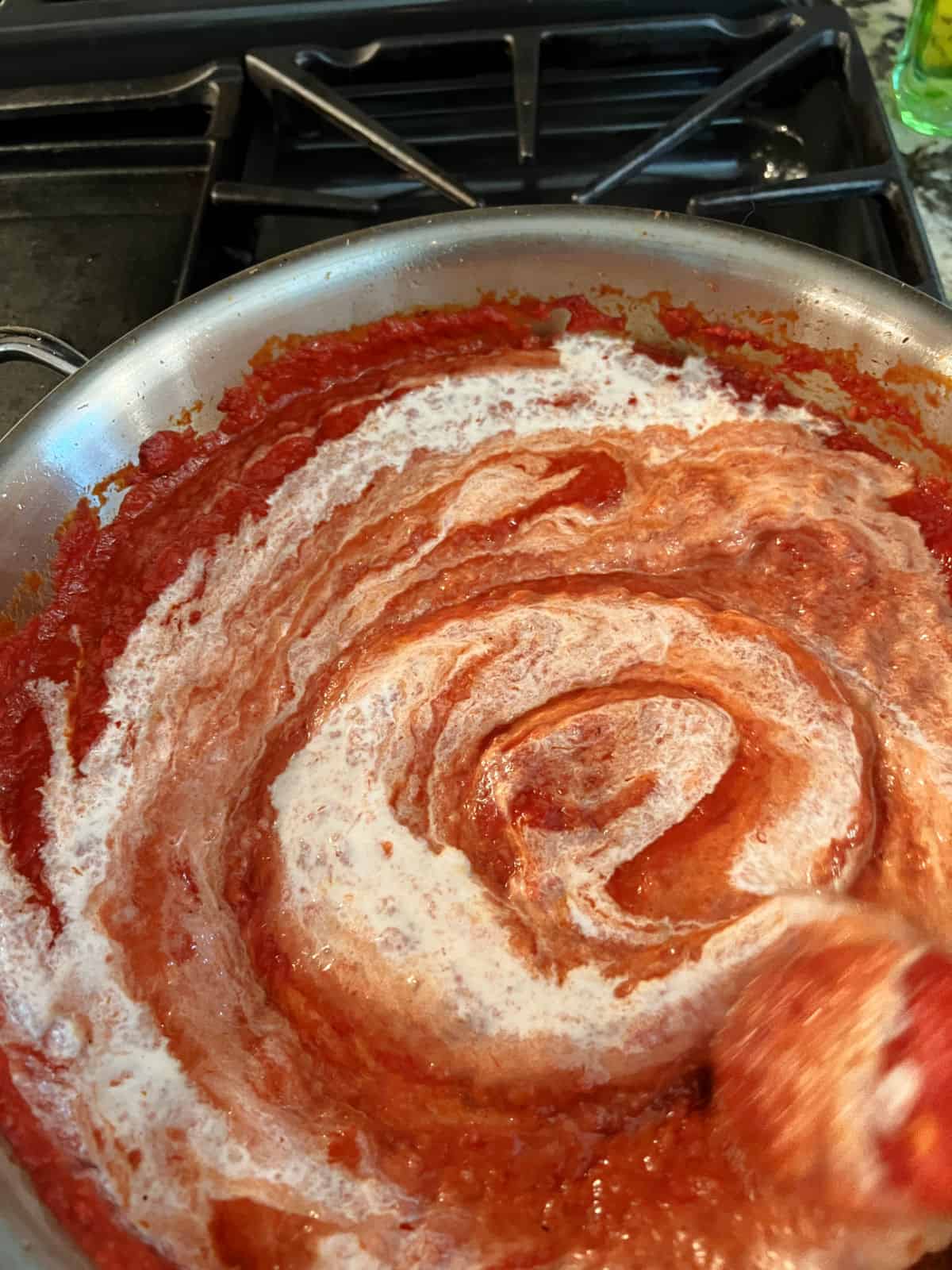 cream stirring into the tomato sauce.