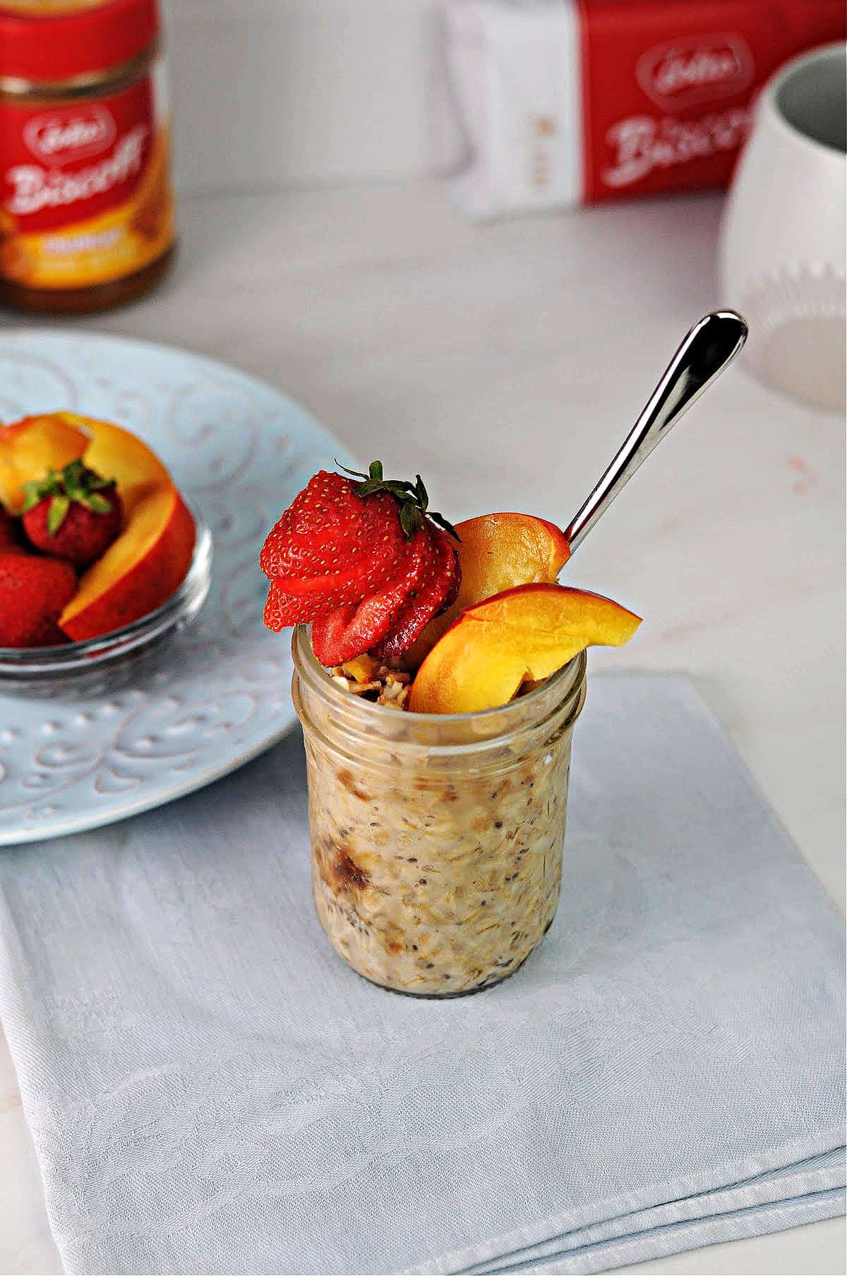 Biscoff overnight oats in a small jar garnished with fruit.