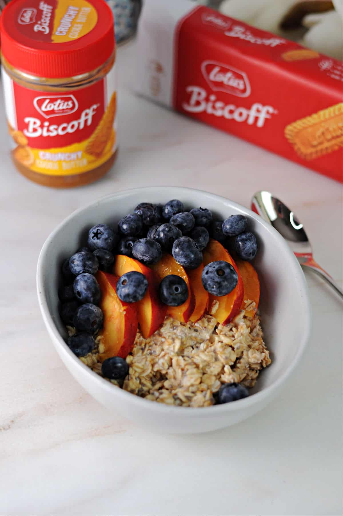 bowl of cookie butter overnight oats garnished with blueberries and nectarine slices.