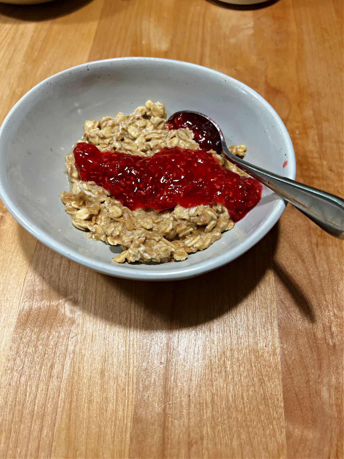 bowl of oatmeal with raspberry jam.