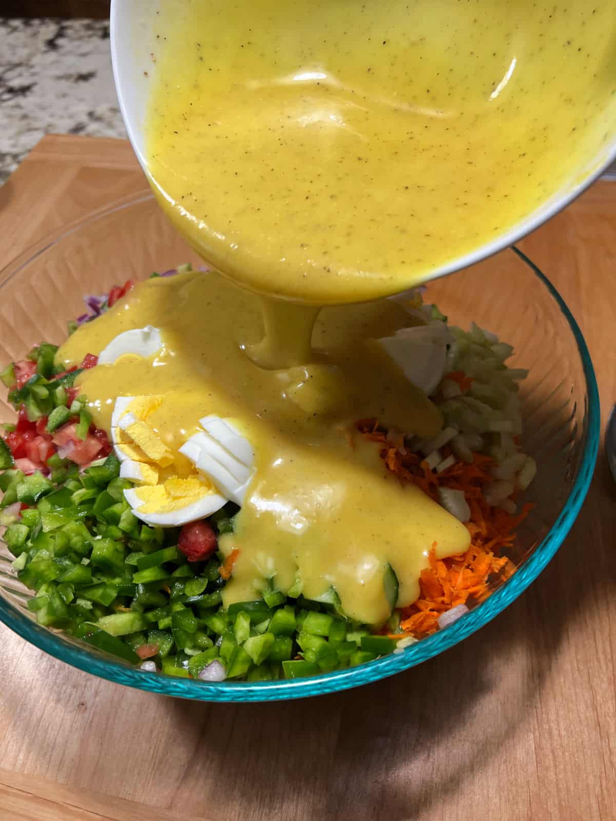 pouring dressing over the salad.