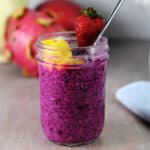 small jar of dragon fruit chia seed pudding garnihed with fresh fruit.