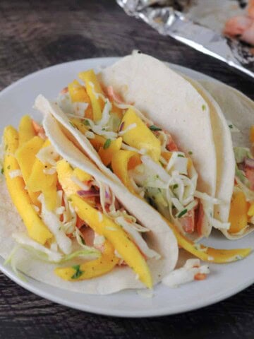 3soft shell fish tacos with mango slaw on top.