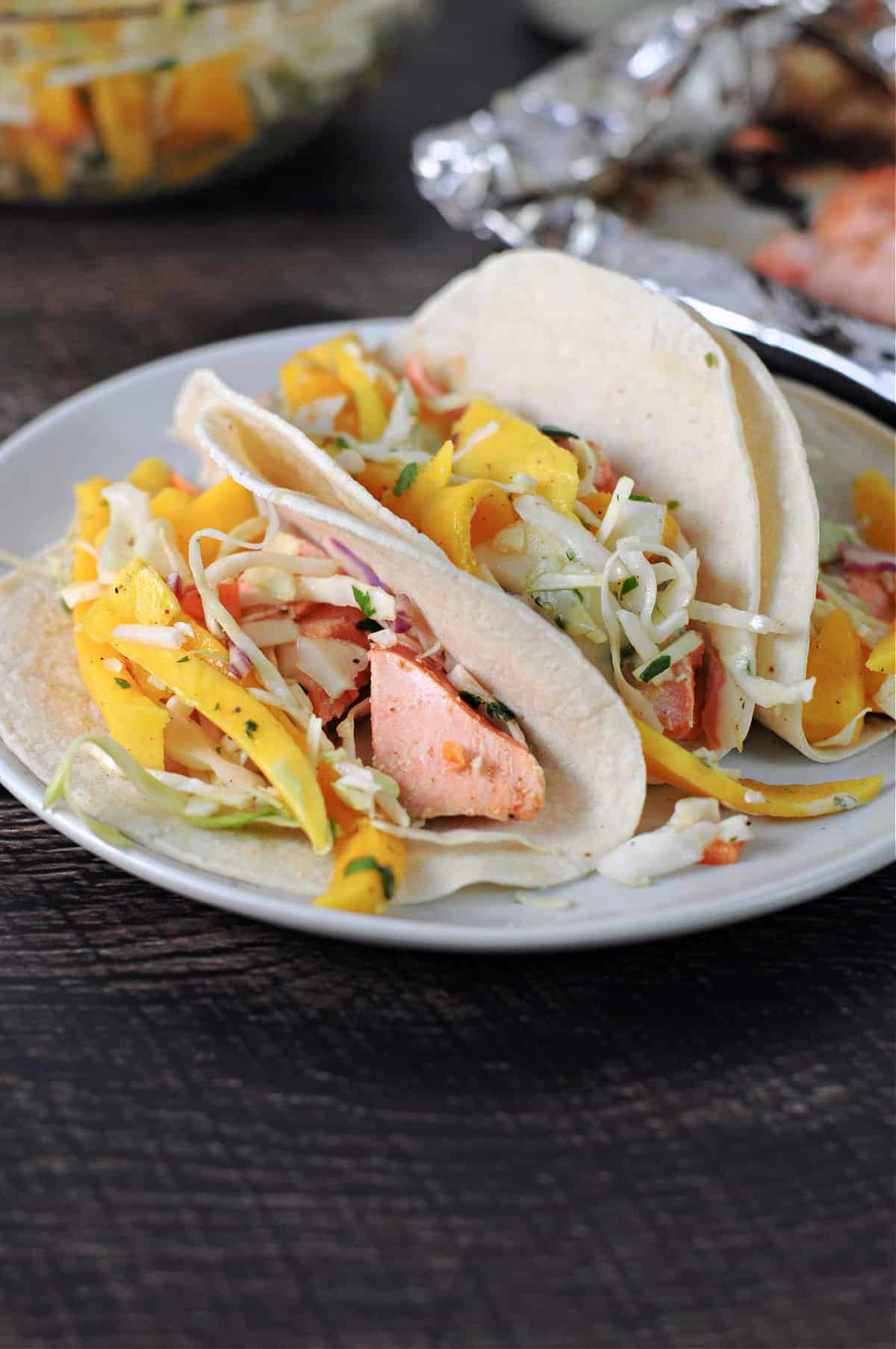 3 tortillas filled with flacked bbq salmon and mango slaw.