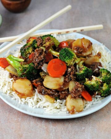 plate of shaved beef and broccoli stir fry on white rice.