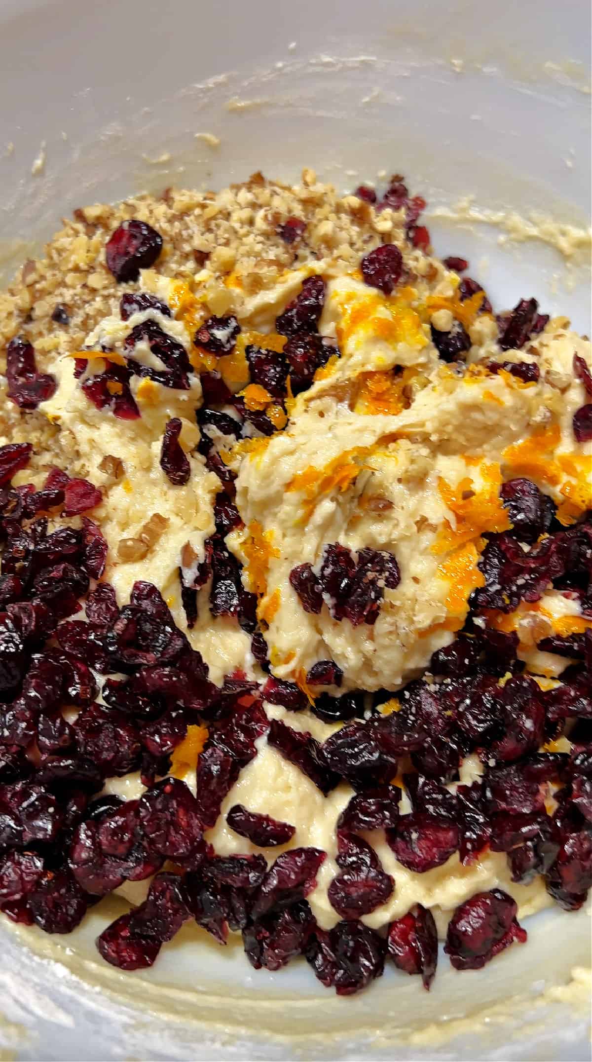 adding dried cranberries, walnuts, and orange zest to muffin batter.