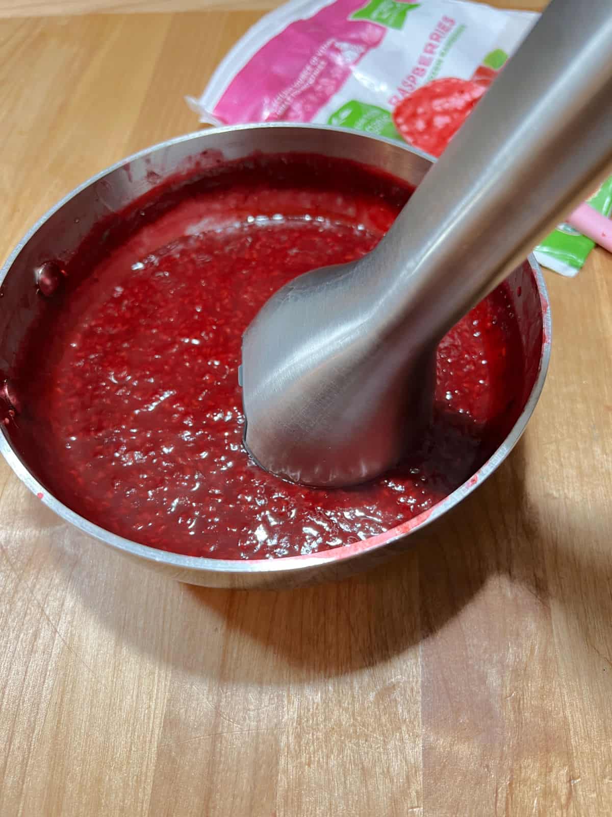 immersion blender in the pan helping to make the cooked sauce smoother.