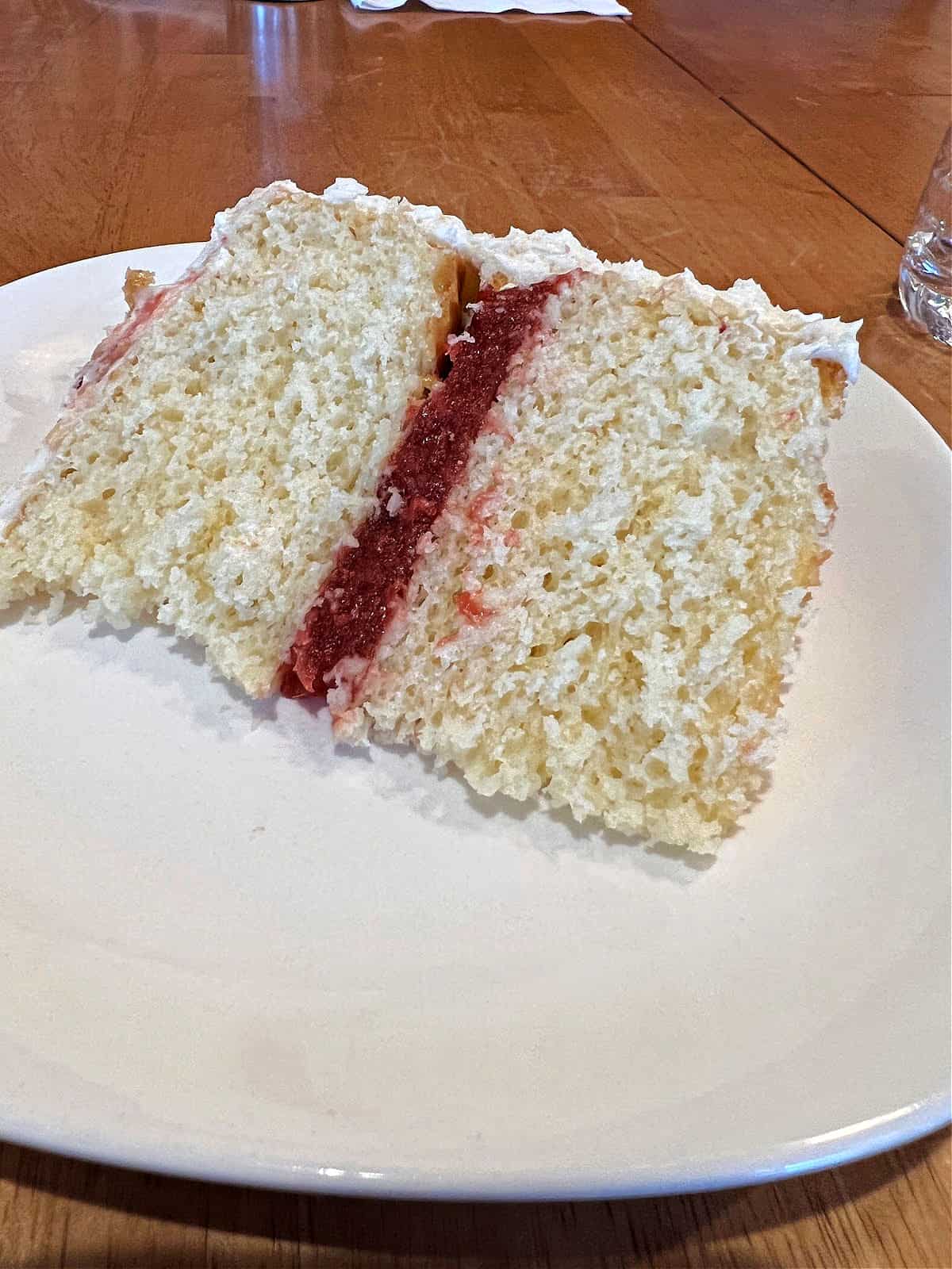 slice of 2 layer vanilla cake with strawberry filling.