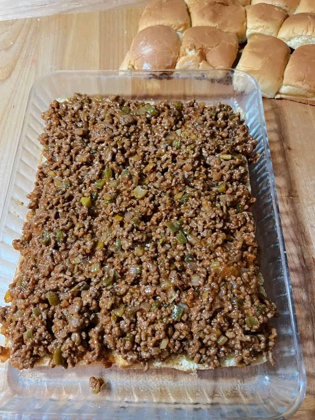 Sloppy Joe meat covering the bottom layer of rolls.