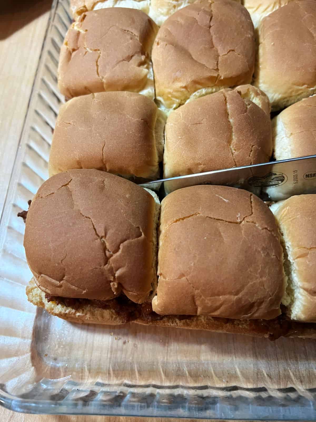 knife cutting the individual sloppy joe sliders from the group.