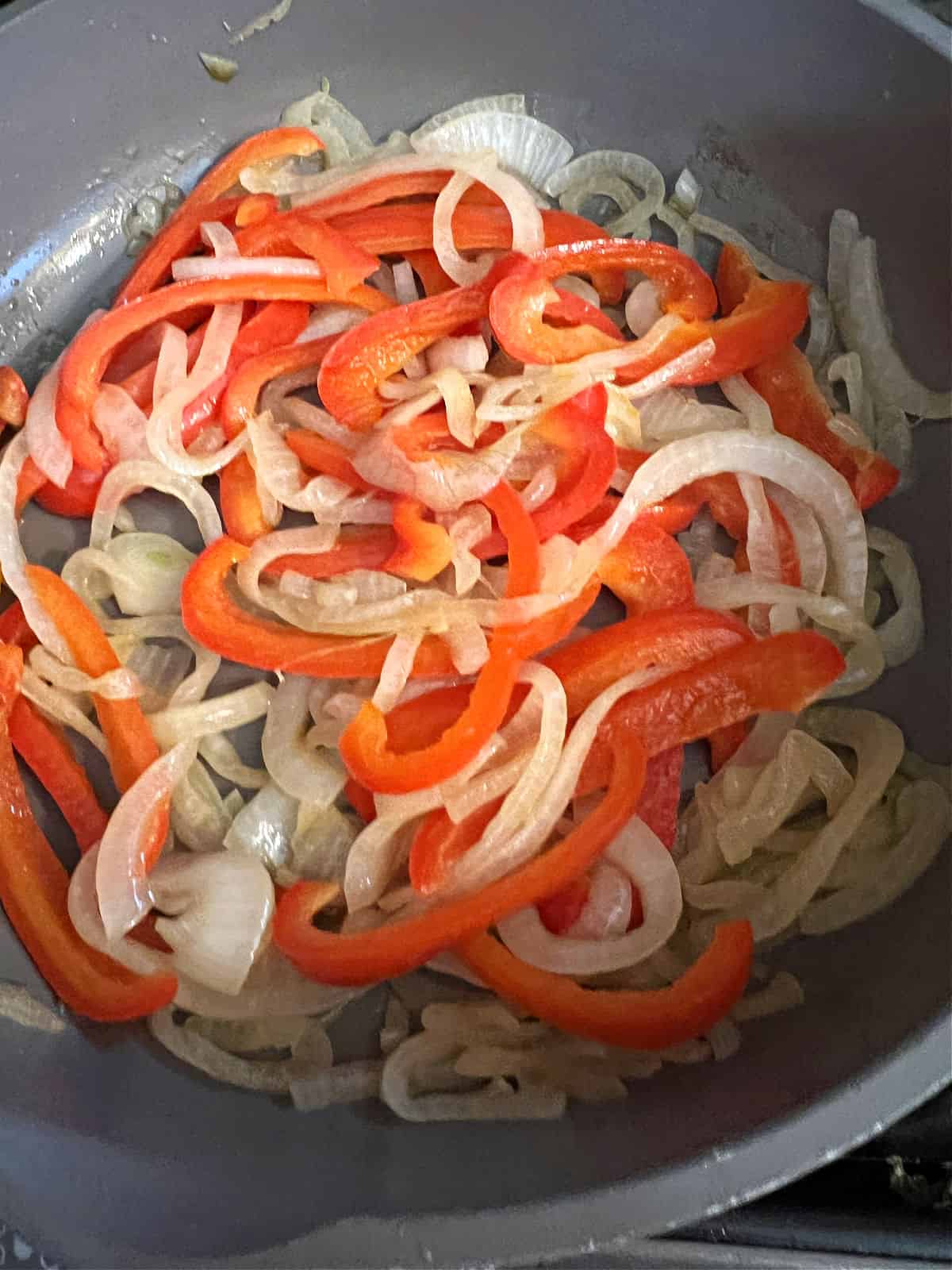 pepper and onion cooking in a skillet.