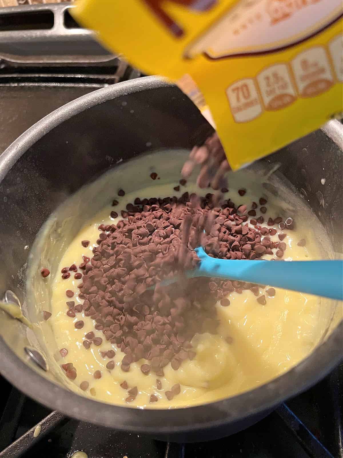 adding chocolate chips to the saucepan.