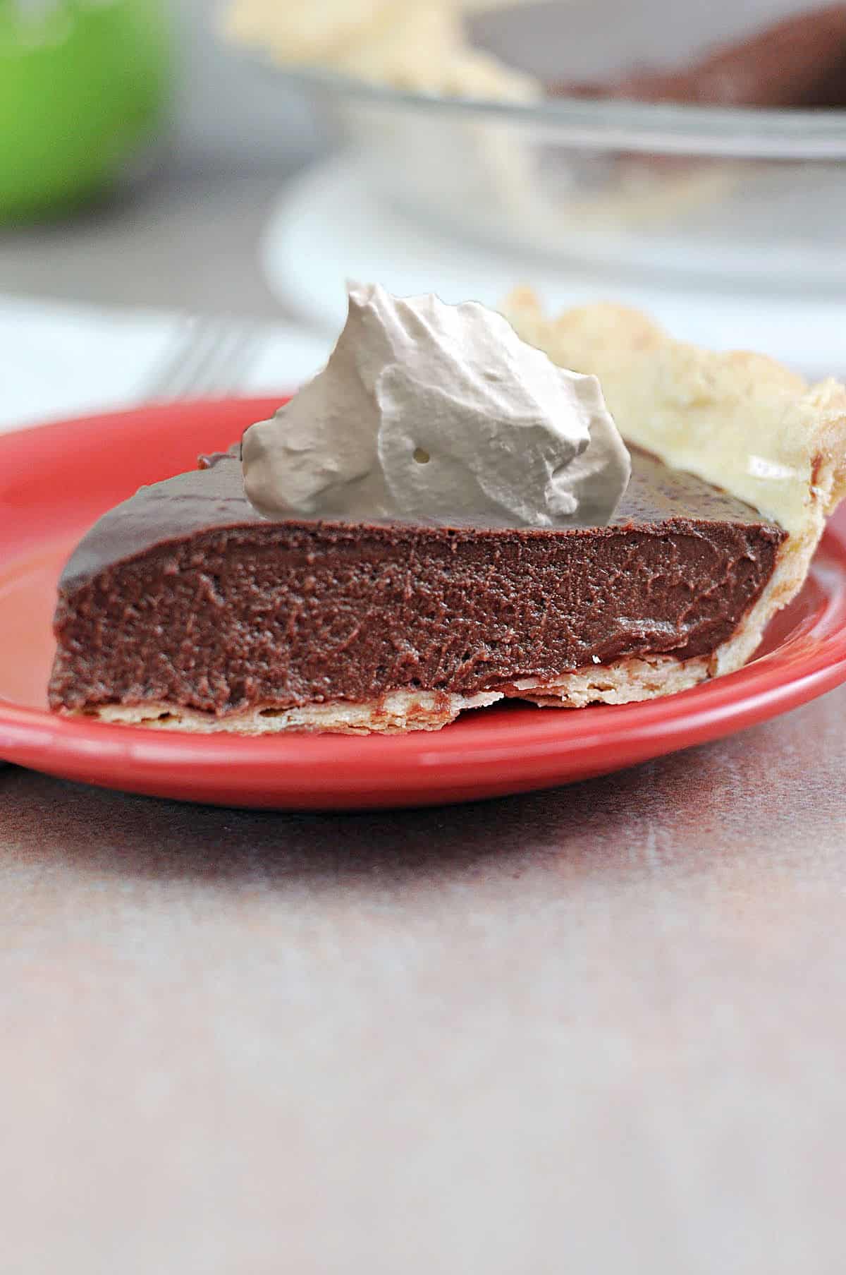slice of no bake chocolate pie topped with whipped cream.