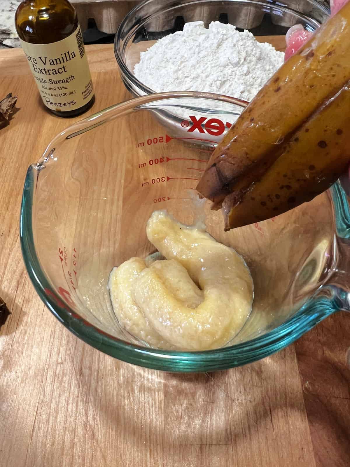 thawed from frozen banana being squeezed into measuring cup.