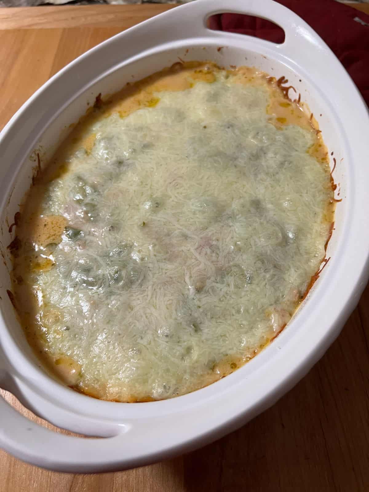 Cooked casserole showing bubbly edges and melted top layer of cheese.